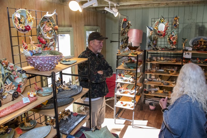 Rehoboth artist John Cooley discusses his whimsical ceramic creations with fellow artists.